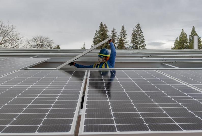 A worker installs a solar panel on Pacific's campus